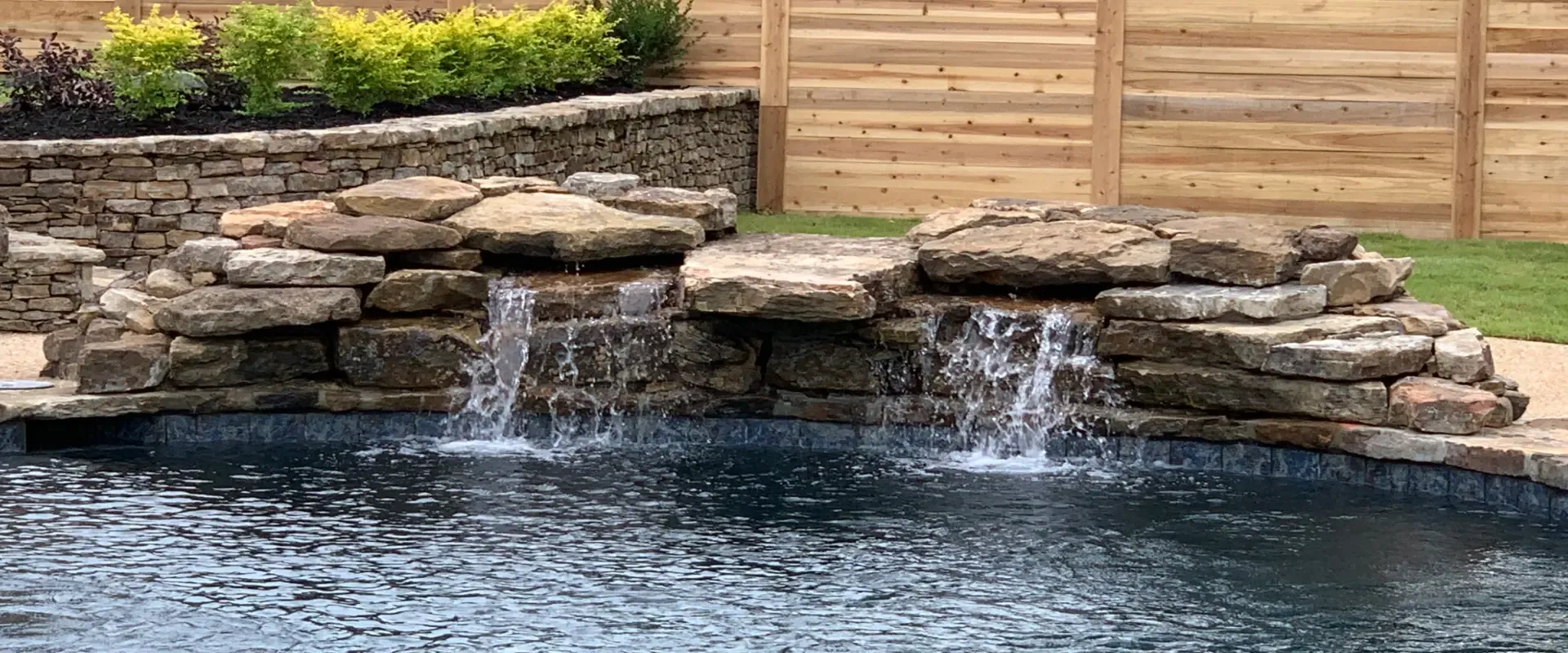 New pool construction with a stone waterfall.