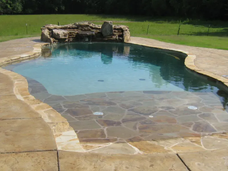 A natural stone swimming pool with beach entry.